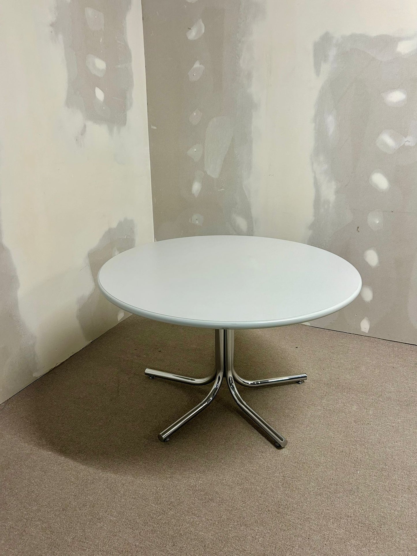 Runder Tisch mit Chrom-Füsse und grau-weisser Platte